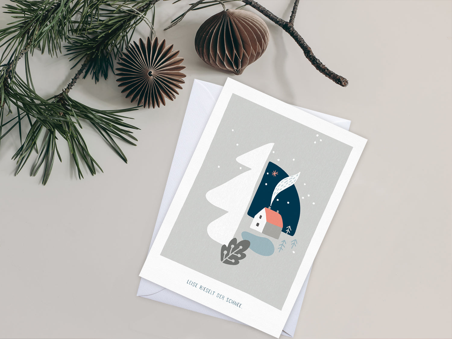Weihnachtskarte im Scandi Nordic Stil als kleiner Postkartengruß, illustriert mit einer ruhigen, verschneiten Winterlandschaft und dem Spruch »Leise rieselt der Schnee«, in sanften Pastellfarben.  Durch die gedeckten Pastelltöne und minimalistischem Nordic Design zaubert diese Weihnachtskarte eine gemütliche Atmosphäre unter den Tannenbaum.